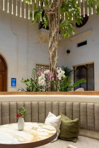 a table with a tree in the middle of a room at Kempinski Hotel San Lawrenz in San Lawrenz