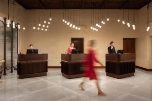 a woman in a red dress walking through a lobby at Kempinski Hotel San Lawrenz in San Lawrenz