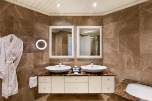 a bathroom with two sinks and a tub at Kempinski Hotel San Lawrenz in San Lawrenz