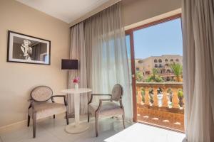 a room with a table and chairs and a large window at Kempinski Hotel San Lawrenz in San Lawrenz