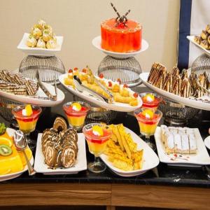 een buffet met veel verschillende soorten eten op borden bij Sunday Luxury Central formerly Anan hotel in Riyad +54 foto's