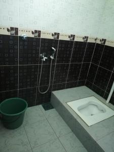 a bathroom with a toilet in a black tiled wall at Tiffana Homestay in Kampong Ayer Terjun +24 photos
