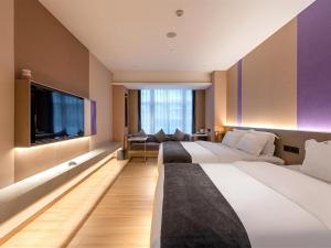 a hotel room with two beds and a flat screen tv at Lavande Hotel Zhongshan Lihe Square in Zhongshan +103 photos