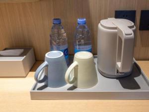 北京Super 8 Hotel Beijing South Railway Station Majiabao Metro Station的托盘,装有两杯和两瓶水