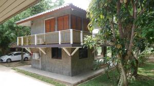 a house with a balcony on the side of it at Rublom Resort Mae Taeng in Mae Taeng