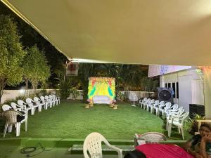 a room with chairs and a table and a stage at GP Villa in Guntūr