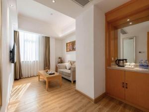 un salon avec un canapé et une table dans l'établissement Vienna Hotel Guangdong Foshan Wenhua North Road, à Nanhai