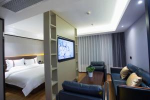 a hotel room with a bed and a flat screen tv at Gya Hotel Beijing Shunyi Yanjing Bridge in Shunyi +216 photos