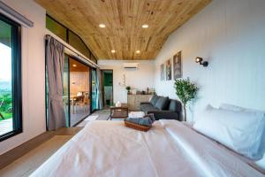 Un dormitorio con una cama grande y una sala de estar. en THUNWA the CAMPSITE, en Khao Kho
