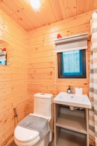Un baño con un inodoro blanco y un lavabo. en THUNWA the CAMPSITE, en Khao Kho