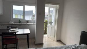 a kitchen and dining room with a table and a window at Sun Shine Studio With Balcony in Larnaka
