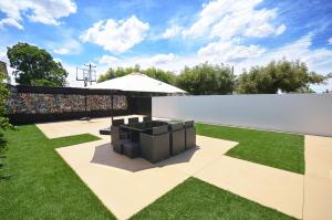 a garden with a bench and an umbrella at No.40 Echuca - Echuca Holiday Homes in Echuca