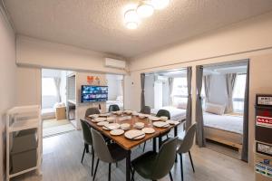 a room with a table and chairs and a bedroom at GoodStay401 in Kurume