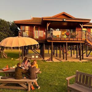 a family sitting at a picnic table in front of a house at Rivers End Farm Stanford with solar energy in Stanford