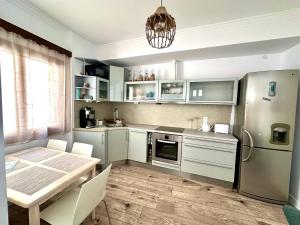 a kitchen with a table and a refrigerator and cabinets at MonJa puhkemaja in Marathokampos