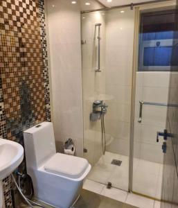 a bathroom with a shower and a toilet and a sink at ضاحية السيف in Karbābād