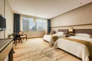 Postelja oz. postelje v sobi nastanitve Zhangjiagang Guomao Hotel