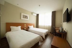 a hotel room with two beds and a television at Jinjiang Inn Style Shenyang The Palace Huaiyuan Gate in Shenyang +101 photos