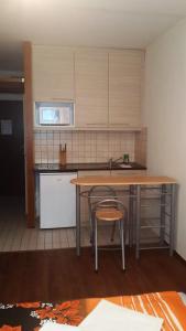 ブダペストにあるJudit Apartmanokのキッチン(テーブル、椅子2脚、シンク付)