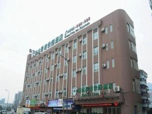 a large brown building on a city street at GreenTree Inn Zhejiang Ningbo Exhibition and Convention Center Bus East Station Express Hotel in Ningbo