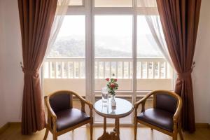 a table and two chairs in front of a window at Nhat Vy Hotel in Ấp Ða Lợi