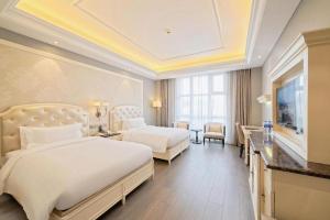 a hotel room with two beds and a television at Yin Run Jin Jiang Castle Hotel in Huzhou