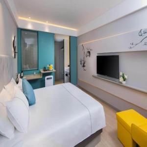 上海市にあるMagnotel Hotel Shanghai Jinjiang Park Branchの大きな白いベッドとテレビのある寝室 +229枚の写真