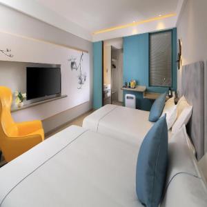 上海市にあるMagnotel Hotel Shanghai Jinjiang Park Branchの大きなベッドとテレビがあるホテルの部屋