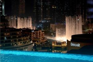 vista su una città di notte con fontana di The Address Fountain Views Residence High Floor with Burj Khalifa view and access to Dubai mall a Dubai
