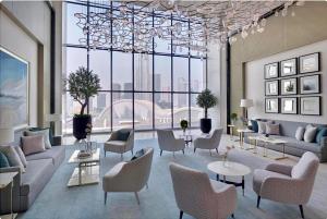 un soggiorno con divani, sedie e una grande finestra di The Address Fountain Views Residence High Floor with Burj Khalifa view and access to Dubai mall a Dubai Altre 25 foto