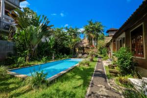 a swimming pool in the backyard of a house at Taman Lituhayu Cottages Ubud in Ubud