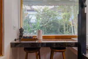 a window with a table and two stools in front of it at Taman Lituhayu Cottages Ubud in Ubud