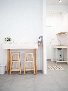a kitchen with a white counter and two stools at Unyak Room Ayutthaya in Phra Nakhon Si Ayutthaya +114 photos