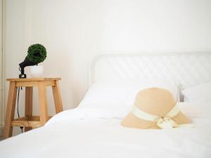 a white bed with a hat on top of it at Unyak Room Ayutthaya in Phra Nakhon Si Ayutthaya