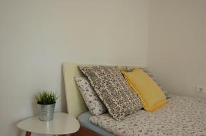 a couch with pillows on it next to a table at Apartments Lucija in Portorož
