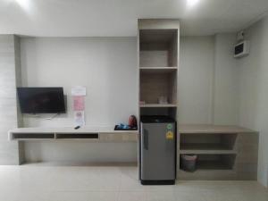 a room with a small refrigerator and a desk at Sattahip 9 Boutique Hotel in Pattaya Central