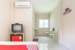 Camera con letto, TV e tavolo di OYO 75317 Pintara Fahsai Resort a Mu Si
