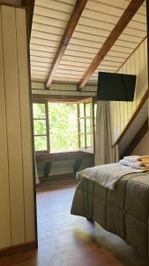 a bedroom with a bed in a room with windows at Complejo de Bungalows del Lago Km13 in San Carlos de Bariloche