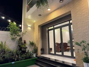 a building with a large glass door with plants at Villa 26-28 Châu Đốc in Chau Doc