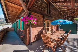 a table and chairs on the porch of a cabin at Appartement spacieux à Châtel 120 m² avec terrasse privée in Châtel