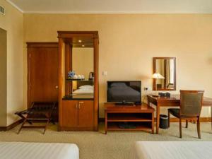 a hotel room with a bedroom with a desk and a television at New Century Hotel Ninghai in Shang-ts'un +231 photos