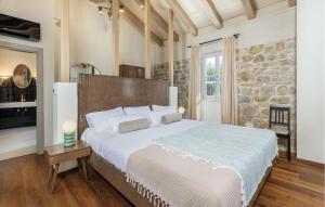 ein Schlafzimmer mit einem großen Bett und einer Steinwand in der Unterkunft 1 Bedroom Amazing Home In Mundanije in Mundanije