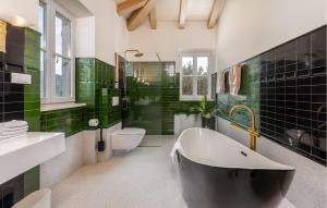 ein Badezimmer mit einer schwarz-grün gefliesten Wand in der Unterkunft 1 Bedroom Amazing Home In Mundanije in Mundanije + 24 Fotos