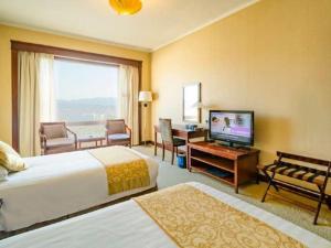a hotel room with two beds and a flat screen tv at New Century Hotel Ninghai in Shang-ts'un