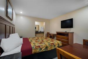 a hotel room with a bed and a flat screen tv at Americas Best Value Inn Redlands San Bernardino in Redlands