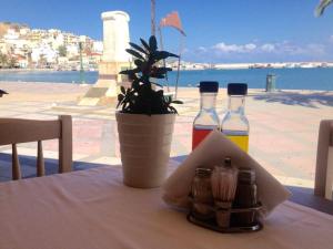 a table with two bottles of juice and a potted plant at Itanos in Sitia