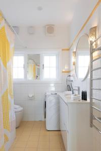a white bathroom with a sink and a toilet at Charming 3-Bedroom Retreat by St Kilda Gardens in Melbourne +47 photos