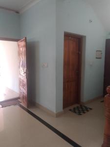 an empty room with a wooden door and a hallway at Home stay in Varkala +4 photos