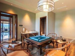 a room with a ping pong table and chairs at Pingtian Bandao Hotel in Chizhou