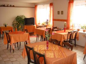 a dining room with tables and chairs with orange table cloth at Asso Penzion in Bojnice